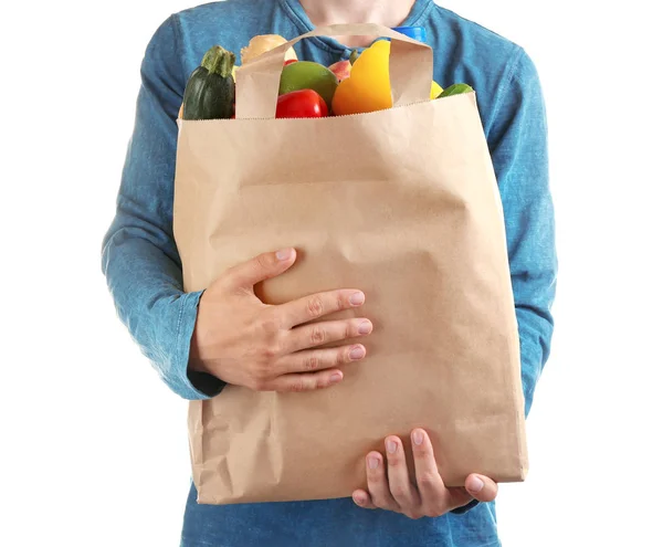 Hombre sosteniendo bolsa de papel con diferentes comestibles sobre fondo blanco, vista de primer plano — Foto de Stock