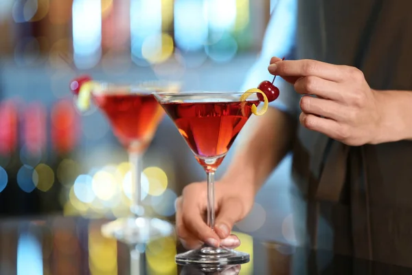 Бармен украшает стакан свежего алкогольного коктейля за барной стойкой — стоковое фото