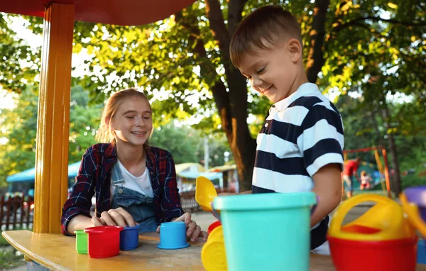 Kindermädchen und süße kleine Junge spielen draußen — Stockfoto