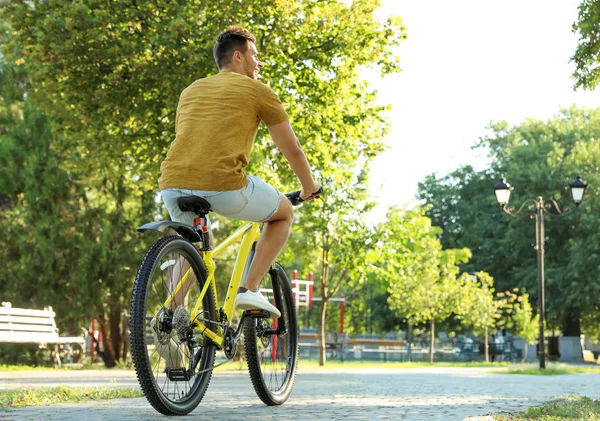 Красивий молодий чоловік з велосипедом у міському парку — стокове фото