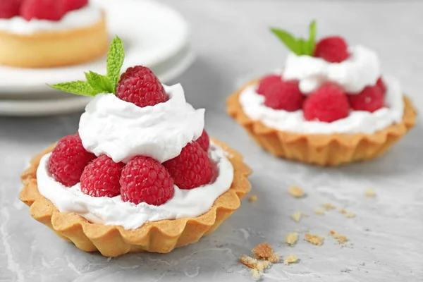 Tarts with raspberries on marble table, closeup. Delicious pastries — Stock Photo, Image