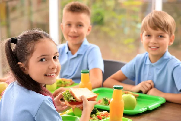 Happy children at table with healthy food in school canteen — Stock Photo, Image