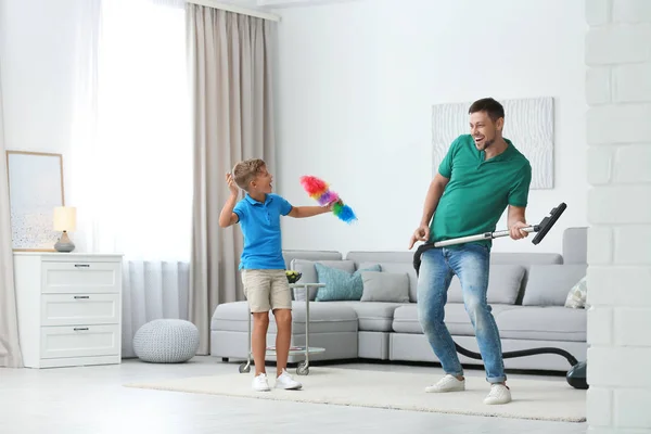 Tatínek a syn se baví, když uklízím obývací pokoj — Stock fotografie