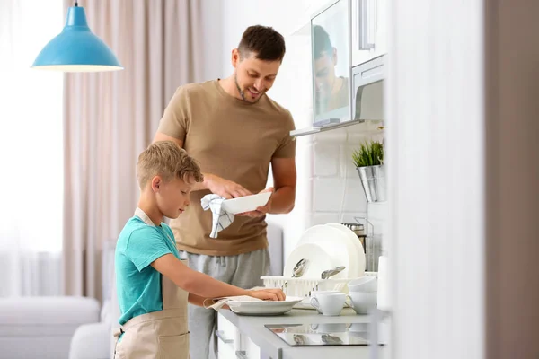 Vater und Sohn wischen Geschirr in der Küche — Stockfoto