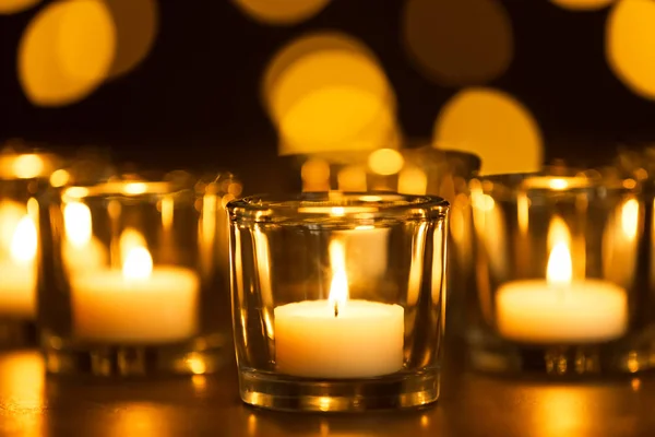 Velas ardientes sobre la mesa sobre fondo borroso. Símbolo funerario —  Fotos de Stock