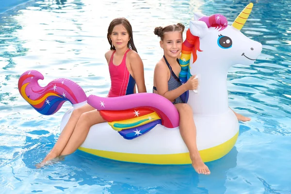 Glückliche Mädchen auf aufblasbarem Einhorn im Schwimmbad — Stockfoto