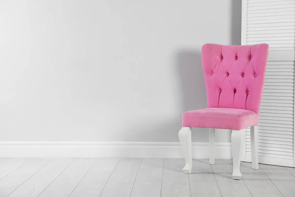 Elegante silla rosa y pantalla plegable cerca de la pared blanca. Espacio para texto — Foto de Stock