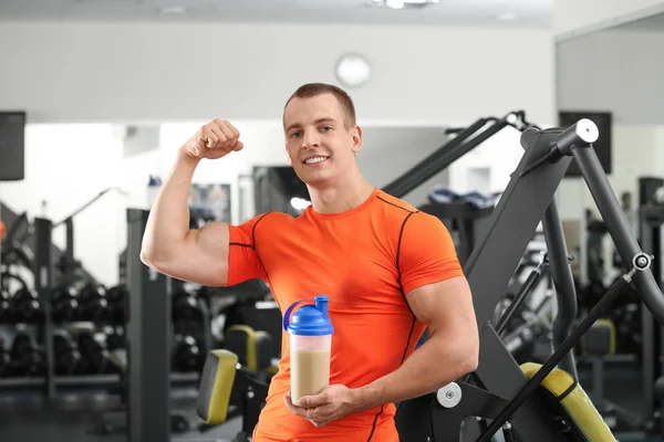 Atletisk ung man med proteinshake i gymmet — Stockfoto