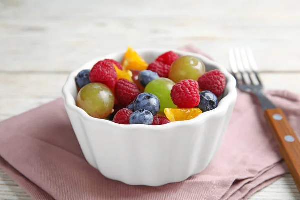 Frischer, schmackhafter Obstsalat auf weißem Holztisch, Nahaufnahme — Stockfoto