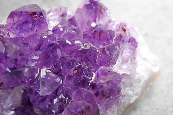 Beautiful purple amethyst gemstone on grey table, closeup — Stock Photo, Image