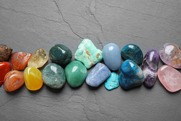 Composición plana con diferentes piedras preciosas sobre mesa gris — Foto de Stock