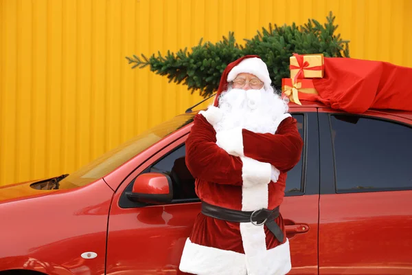 Otantik Noel Baba köknar ağacı ve çanta sarı arka plan karşı çatıda hediyeler dolu araba yakınında