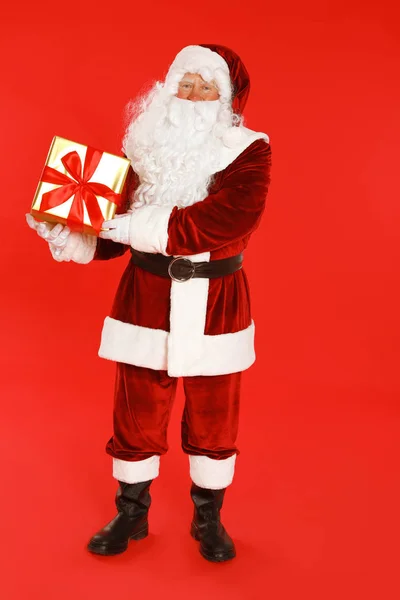 Auténtico Santa Claus con caja de regalo sobre fondo rojo —  Fotos de Stock