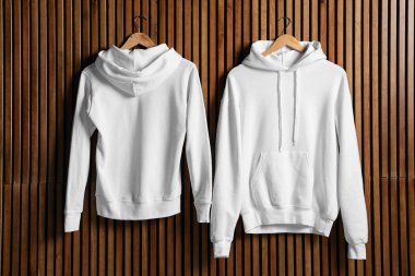 Ahşap duvarda yeni kazak ile Hangers, tasarım için alay