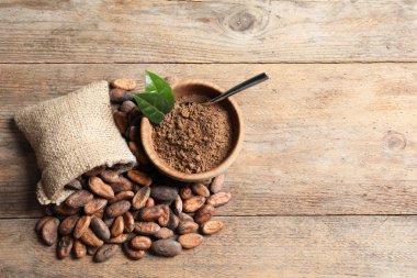 Ahşap masa üzerinde kakao çekirdekleri ve toz ile Düz yatıyordu kompozisyon, metin için alan