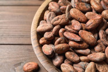 Ahşap masa üzerinde kakao çekirdekleri ile Kase, closeup