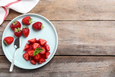 Çilek ve ahşap masa üzerinde nane ile Lezzetli taze kırmızı jöle, düz yatıyordu. Metin için alan