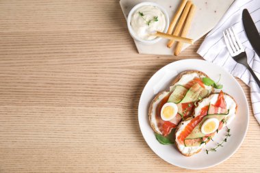 Somon ile lezzetli bruschettas ahşap masada servis, düz yatıyordu. Metin için alan