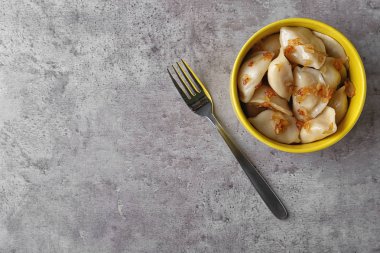 Gri masada kızarmış soğan ile lezzetli pişmiş köfte, düz yatıyordu. Metin için alan