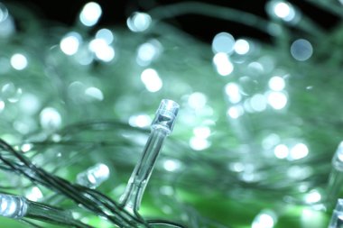 Yeşil arka planda parlayan Noel ışıkları, yakın çekim