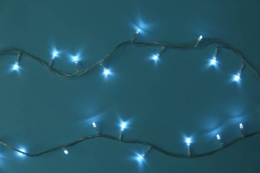 Turkuaz arka plan üzerinde Parlayan Noel ışıkları, düz yatıyordu