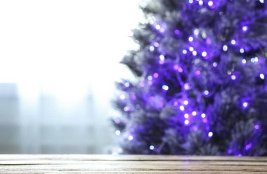 Pencere kapalı yakın mor ışıklar ile güzel Noel ağacıbulanık görünümü, ahşap masa odaklanmak. Metin için alan