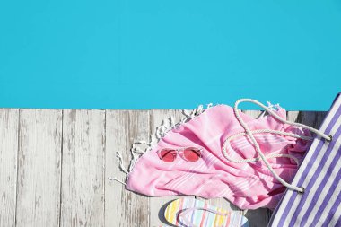 Açık yüzme havuzu yakınında ahşap güvertede Plaj aksesuarları, düz yatıyordu. Metin için alan