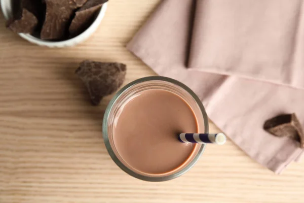 平放置组成与一杯美味的巧克力牛奶在木制背景。乳品饮料 — 图库照片