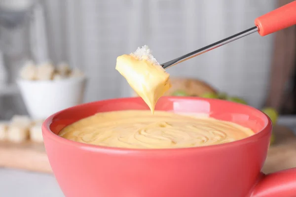 Doppa brödet i potten med ostfondue, närbild — Stockfoto