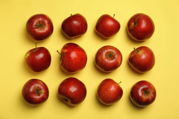 Composición plana con manzanas rojas jugosas maduras sobre fondo amarillo —  Fotos de Stock