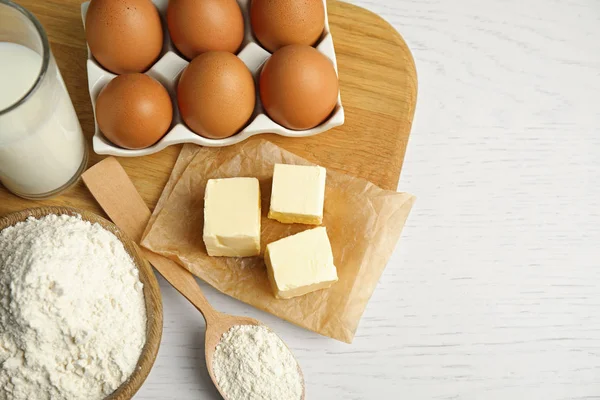 Färska ingredienser för läckra hembakade kakor på vitt träbord — Stockfoto