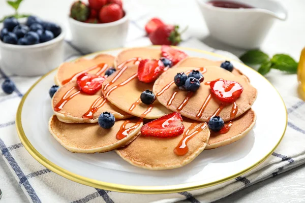 Leckere Pfannkuchen mit frischen Beeren und Sirup auf hellem Tisch — Stockfoto