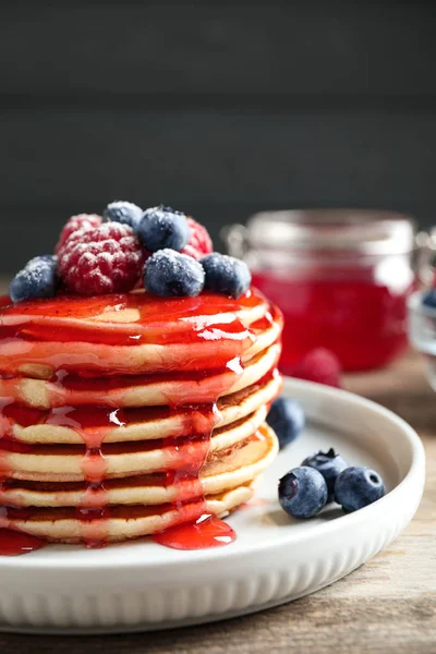 Pancake lezat dengan buah beri segar dan sirup di atas meja kayu — Stok Foto
