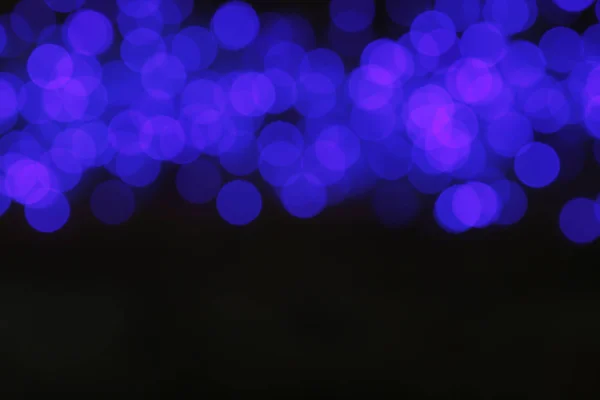 Vista turva das luzes azuis de Natal no fundo escuro — Fotografia de Stock