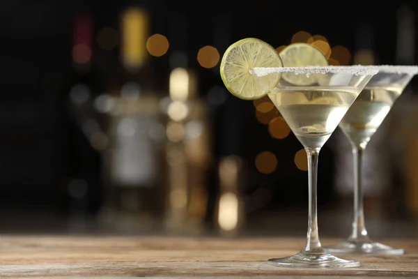 Окуляри коктейлю Lime Drop Martini на дерев'яному столі на тлі розмитого фону. Простір для тексту — стокове фото