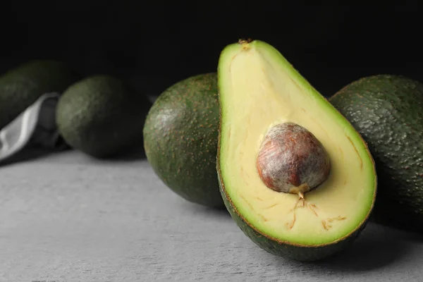 Deliziosi avocado maturi su tavolo di legno grigio — Foto Stock