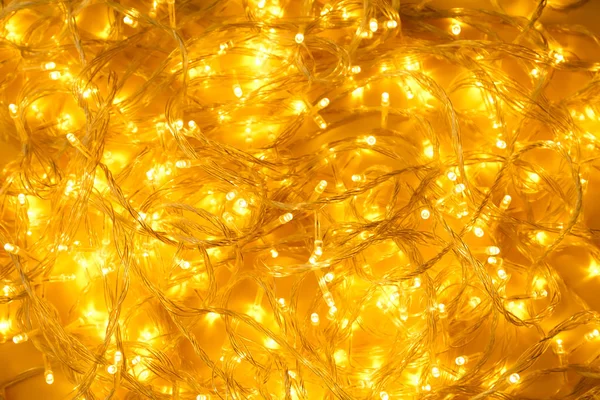 Luces de Navidad brillantes sobre fondo amarillo, vista superior — Foto de Stock