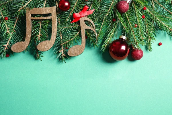 Composizione laica piatta con decorazioni natalizie e note musicali su sfondo verde chiaro, spazio per testo — Foto Stock