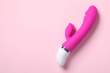 Pembe arka plan üzerinde vibratör, metin için alan ile üst görünüm. Seks oyuncak