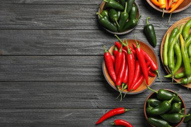 Gri ahşap masa üzerinde farklı olgun biber biber, düz yatıyordu. Metin için alan