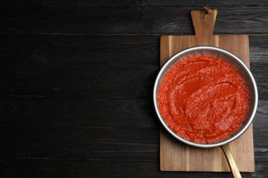 Siyah ahşap masa, üst görünümü üzerinde tavada Lezzetli domates sosu. Metin için alan