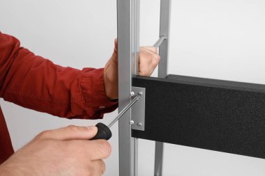 Adam beyaz duvara yakın raf ünitesi sabitleme, closeup görünümü