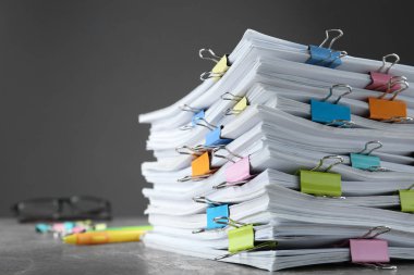 Gri taş masa üzerinde bağlayıcı klipleri ile belge yığını, yakın çekim görünümü. Metin için alan