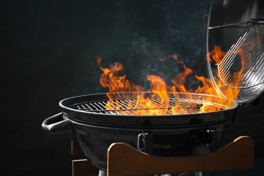 Koyu arka planda yanan ateş ile Modern barbekü ızgara