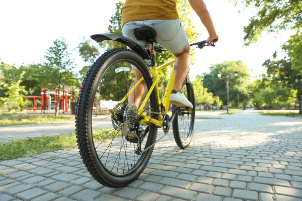 Joven con bicicleta en el parque de la ciudad, primer plano — Foto de Stock