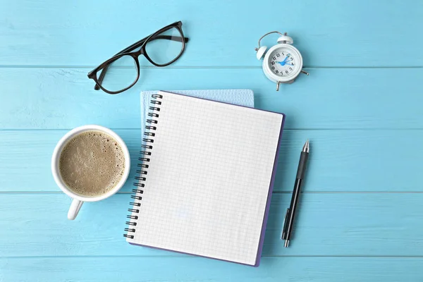 Composición plana con papelería de oficina y taza de café en la mesa de madera azul claro. Espacio para texto — Foto de Stock