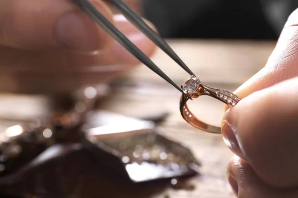 Male jeweler examining diamond ring in workshop, closeup view — Stock Photo, Image