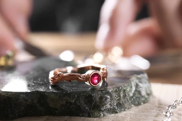 Ruby ring and blurred jeweler on background