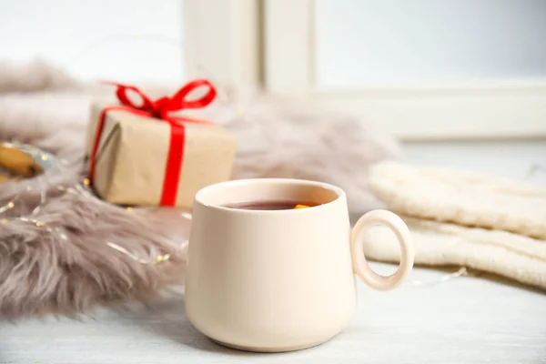 Cup of hot winter drink on window sill — Stock Photo, Image