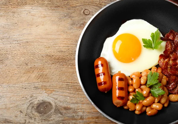 Bratpfanne mit traditionellem englischem Frühstück auf Holztisch, Draufsicht. Raum für Text — Stockfoto